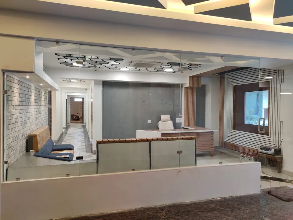 Glass-fronted reception: a white desk and chair before a striped feature wall, a timber-slatted bench and a corridor