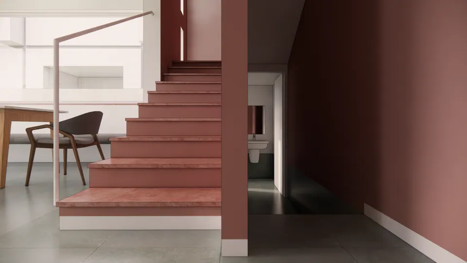 Rendered stair with dusty-pink treads and walls, a slim white handrail and a passage to the bathroom