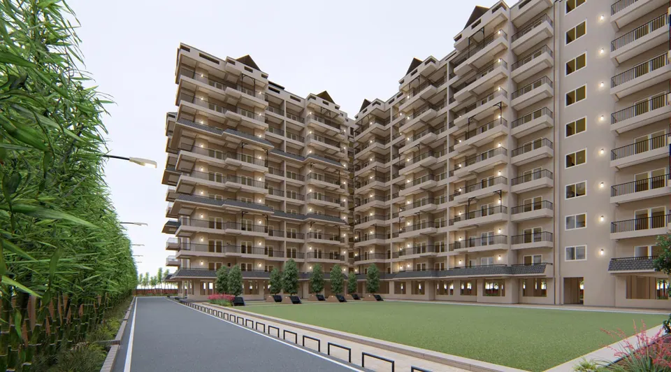 Rendered apartment blocks with lit balconies along an internal road, a bamboo screen and a lawn in front