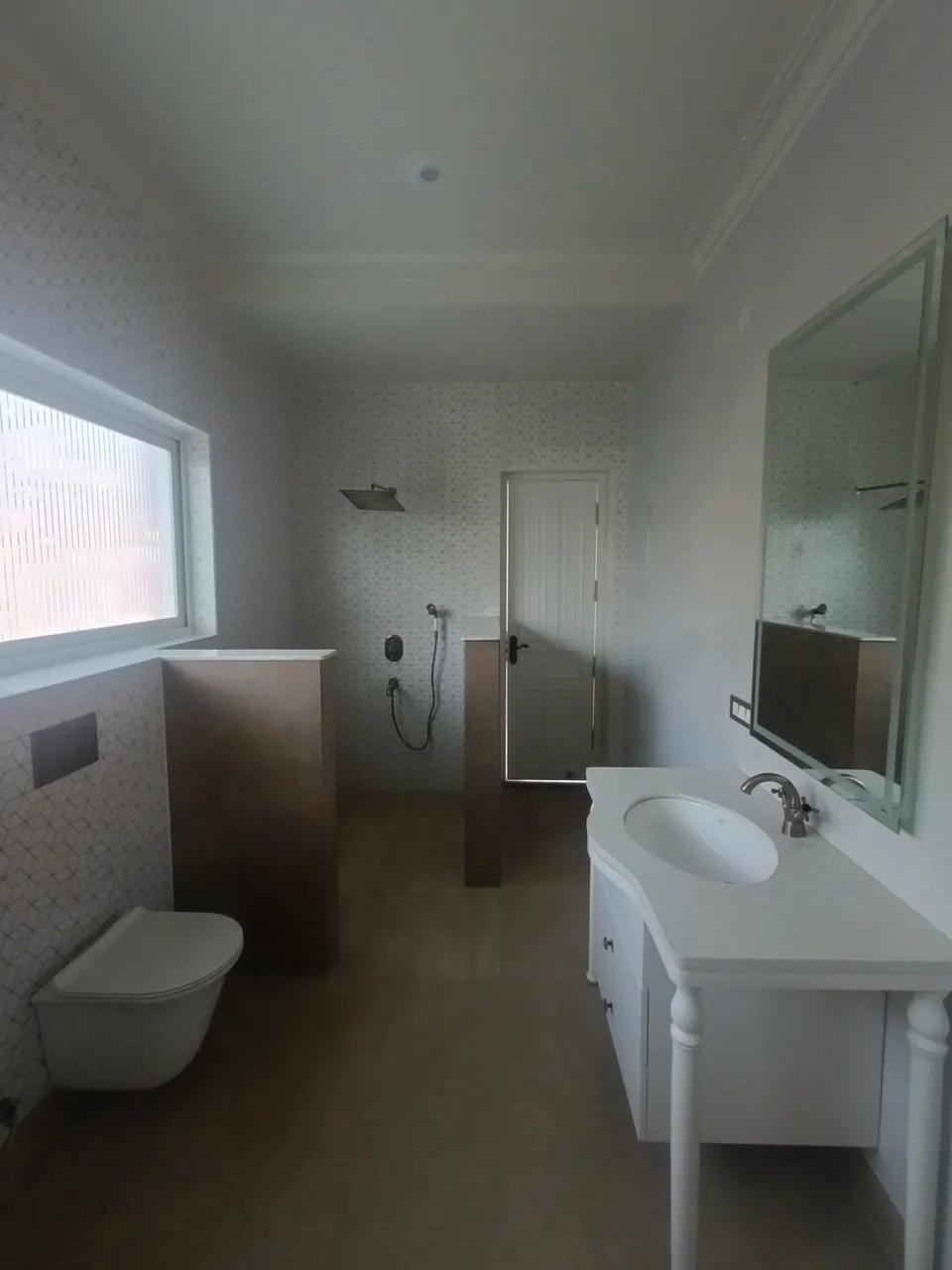 Bathroom with a white vanity and mirror, a wall-hung WC, a rain shower and a frosted window
