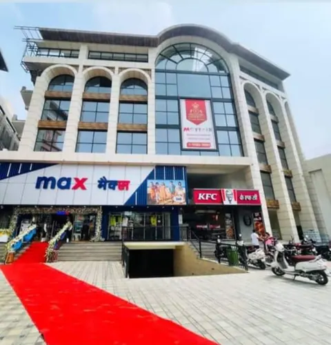 Arched glass-and-stone commercial facade with store signage over the ground floor and a red carpet laid to the entrance