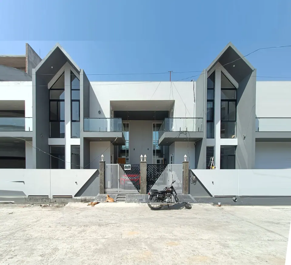 Pair of mirrored row houses: tall grey gabled frames with full-height glazing, white walls, glass balconies and grey gates