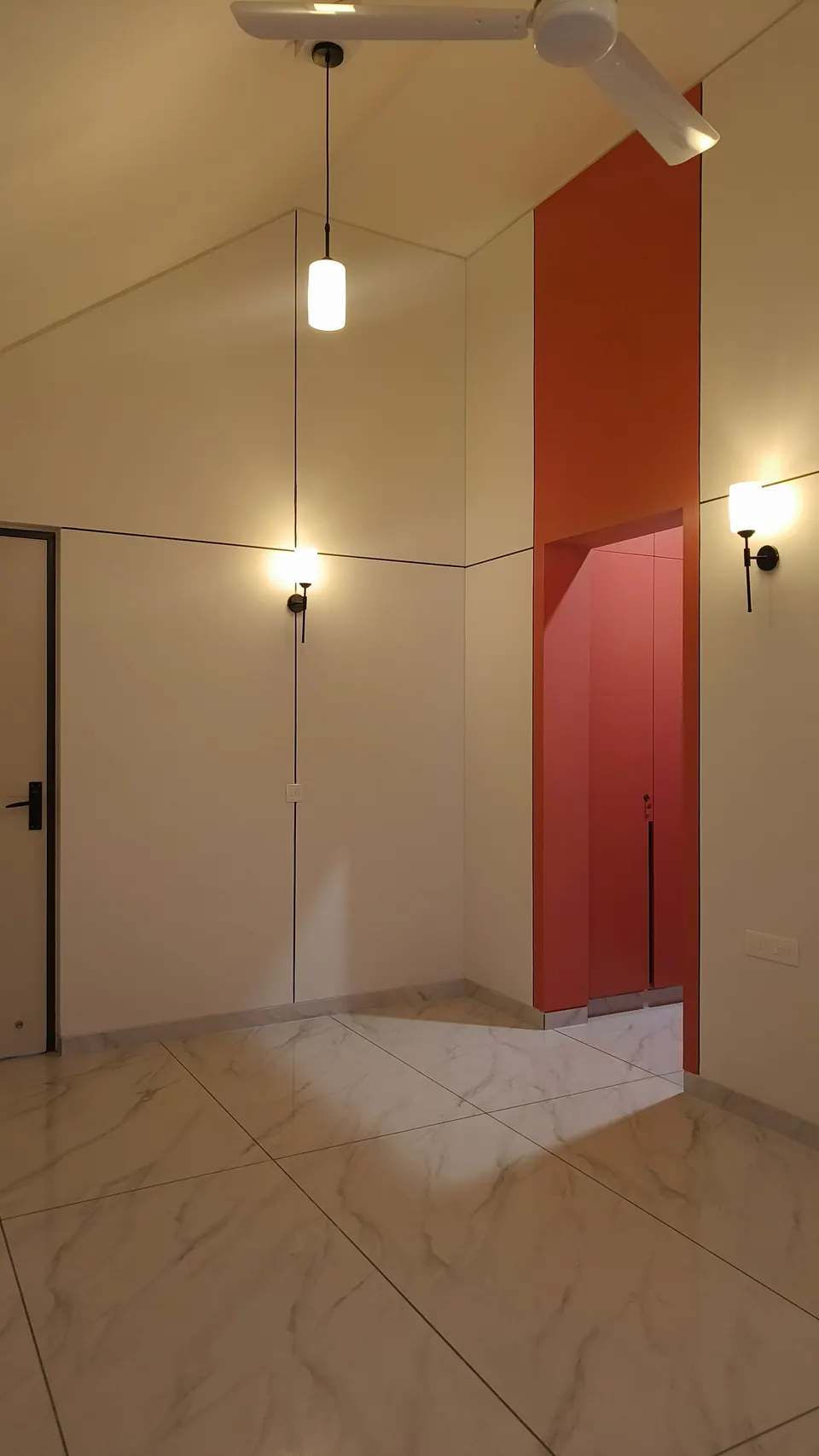 Room under a gabled ceiling with a pendant light, wall lamps and a coral-red wardrobe niche