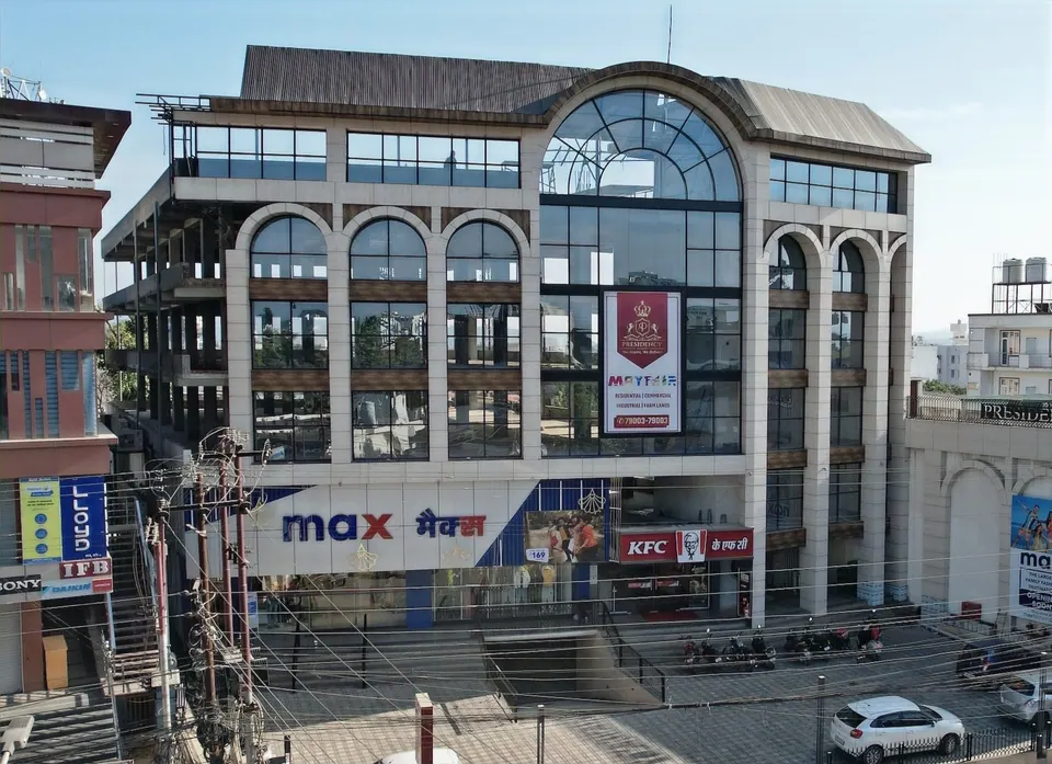 Raised view of the four-storey commercial block with its arched central window, forecourt parking and the street
