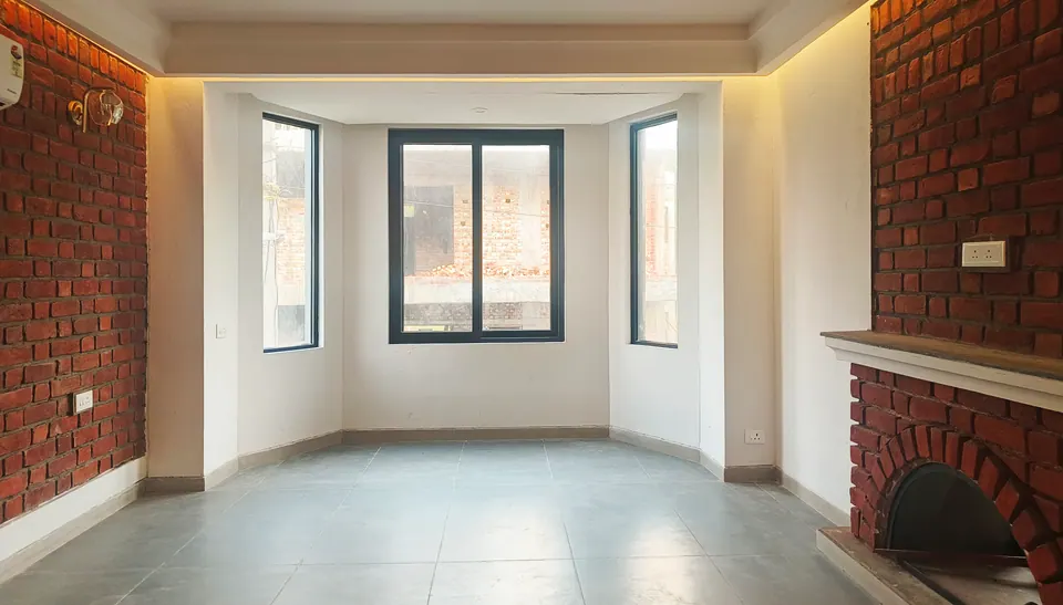 Living room with exposed-brick walls, a brick fireplace with an arched opening and a three-sided bay window