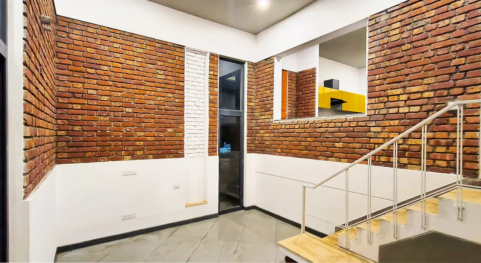 Room with exposed brick walls, an internal window to the kitchen and a stair with white railings