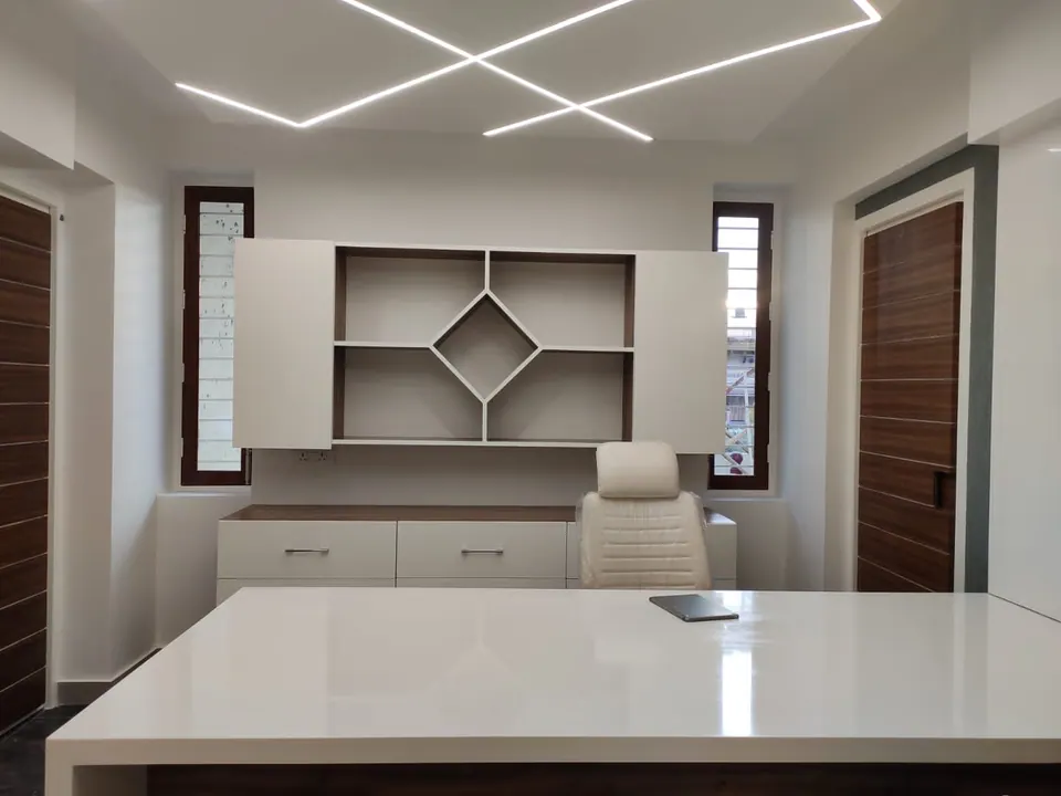 Cabin with a white desk and chair before white shelving with a diamond motif, timber doors and crossed linear lights